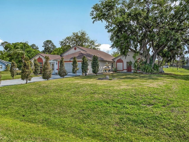 view of front of property with a garage, concrete driveway, and a front lawn