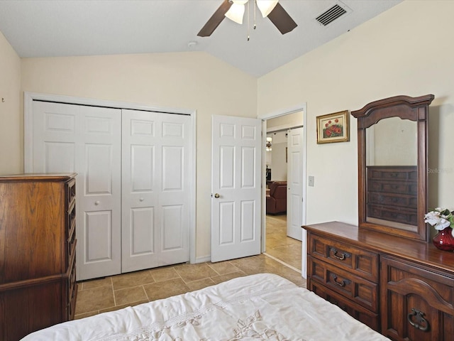 tiled bedroom featuring a closet, visible vents, ceiling fan, and lofted ceiling