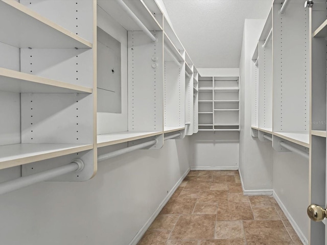 spacious closet featuring stone finish flooring