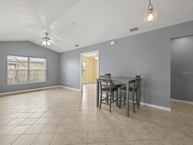 dining room featuring visible vents, light tile patterned floors, baseboards, ceiling fan, and vaulted ceiling