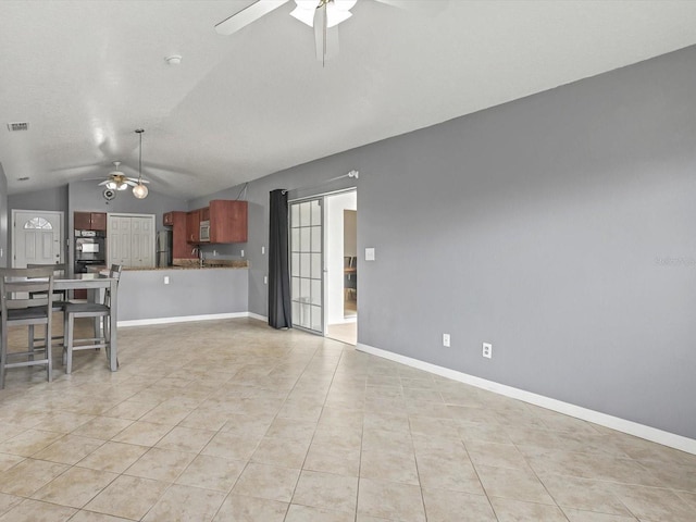 unfurnished living room with visible vents, lofted ceiling, a ceiling fan, light tile patterned flooring, and baseboards