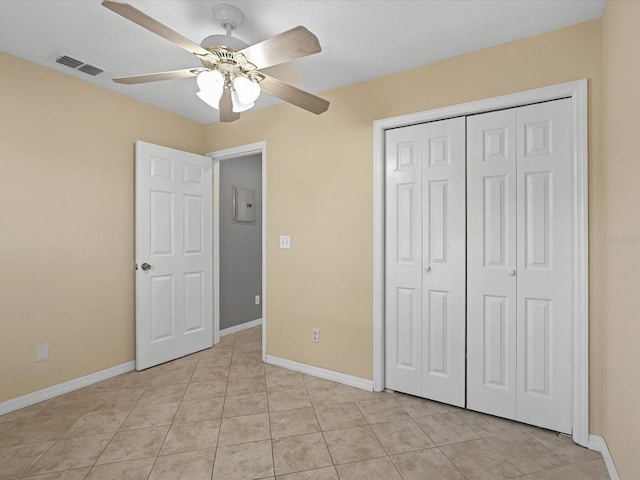 unfurnished bedroom featuring visible vents, baseboards, a closet, and light tile patterned flooring