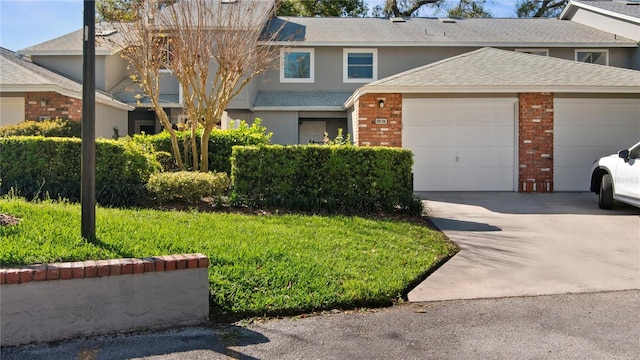 multi unit property featuring brick siding, concrete driveway, roof with shingles, stucco siding, and an attached garage