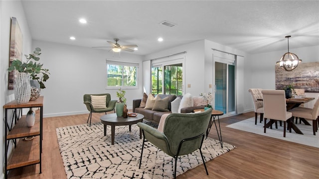 living area featuring visible vents, recessed lighting, baseboards, and wood finished floors