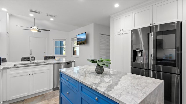 kitchen with white cabinets, blue cabinets, visible vents, and appliances with stainless steel finishes