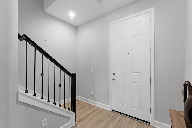 foyer entrance featuring stairs, wood finished floors, and baseboards