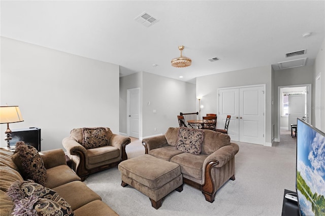 living room with visible vents, light carpet, and baseboards