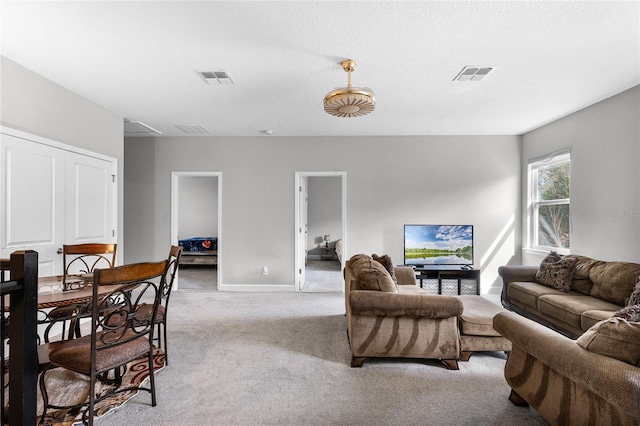 living room featuring visible vents, baseboards, and carpet