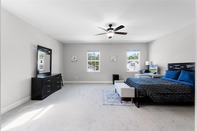 bedroom featuring light colored carpet, baseboards, and ceiling fan