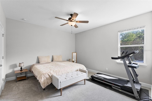 carpeted bedroom with a ceiling fan and baseboards