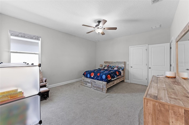 unfurnished bedroom featuring baseboards, visible vents, a textured ceiling, and carpet