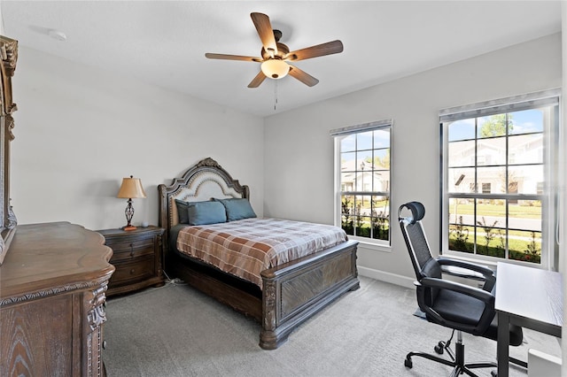 bedroom featuring light colored carpet, baseboards, and ceiling fan