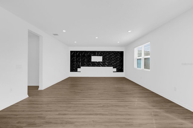 empty room with recessed lighting, wood finished floors, and visible vents