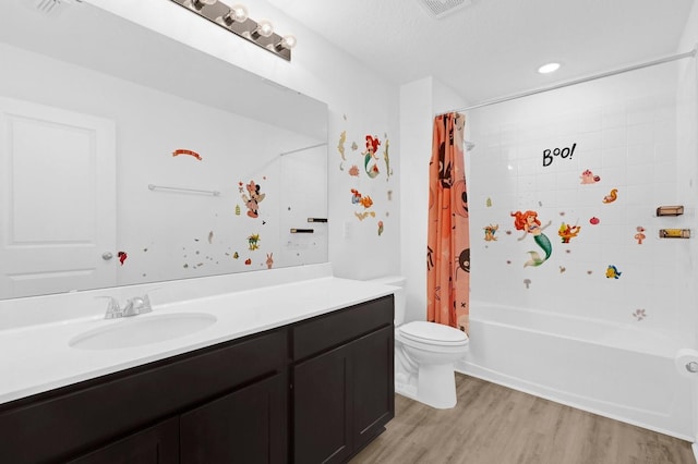 bathroom with visible vents, toilet, wood finished floors, shower / tub combo, and vanity