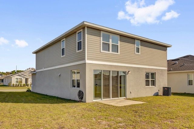 rear view of property with central AC unit, a yard, and stucco siding