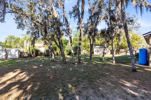 view of yard featuring an outbuilding and fence