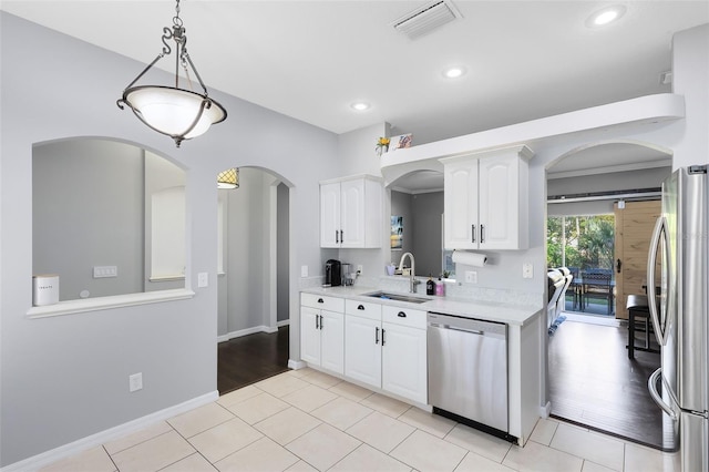 kitchen featuring visible vents, a sink, stainless steel appliances, light countertops, and white cabinetry