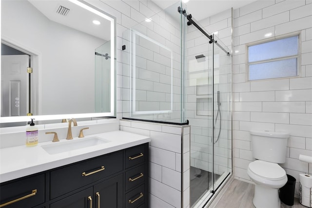 bathroom featuring tile walls, toilet, and a stall shower