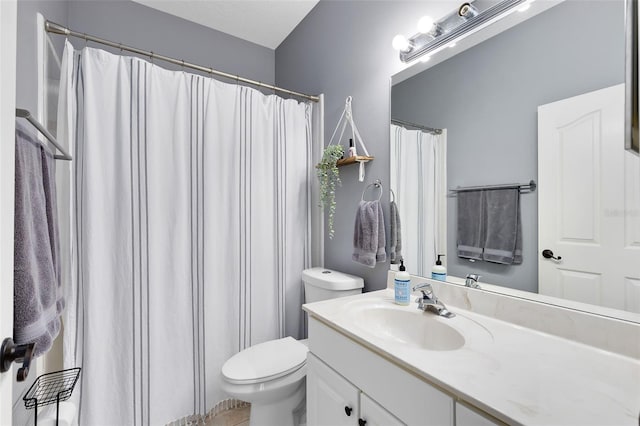 bathroom featuring curtained shower, toilet, and vanity