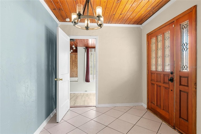 foyer featuring a notable chandelier, ornamental molding, light tile patterned floors, baseboards, and wood ceiling