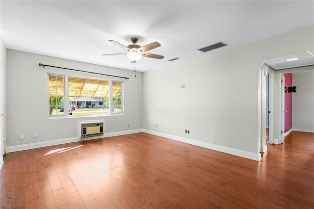 unfurnished room with ceiling fan, visible vents, baseboards, and wood finished floors