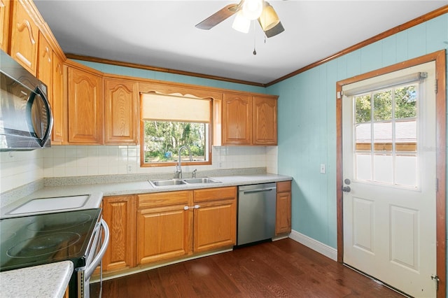 kitchen featuring dark wood-style flooring, a sink, decorative backsplash, light countertops, and appliances with stainless steel finishes