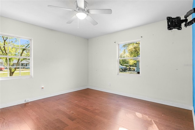 spare room featuring a ceiling fan, wood finished floors, and baseboards