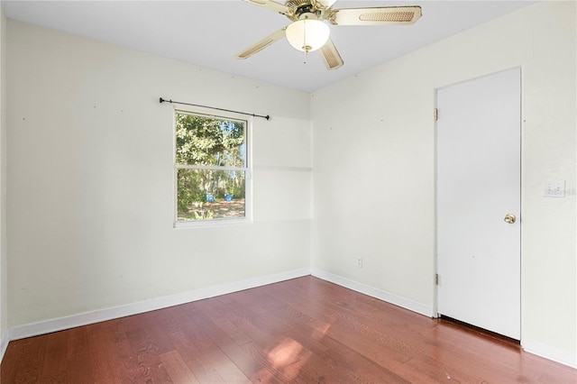 empty room featuring a ceiling fan, wood finished floors, and baseboards