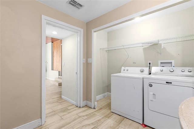 laundry area with visible vents, baseboards, laundry area, light wood-style floors, and independent washer and dryer