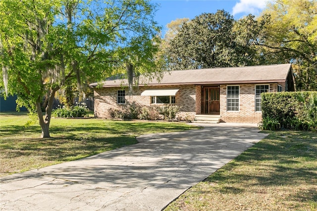 ranch-style home featuring brick siding, concrete driveway, and a front yard