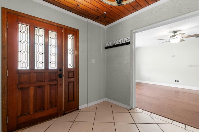 foyer with baseboards, wood ceiling, ornamental molding, light tile patterned floors, and a ceiling fan