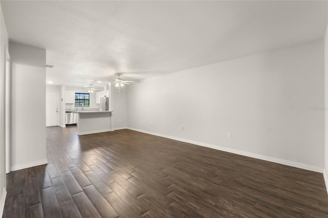 unfurnished living room featuring visible vents, baseboards, dark wood-style floors, and a ceiling fan