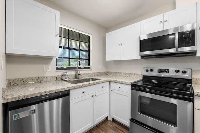 kitchen featuring a sink, stainless steel appliances, light stone countertops, and white cabinets