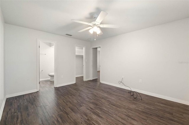 unfurnished bedroom with visible vents, dark wood-type flooring, ensuite bathroom, a closet, and baseboards