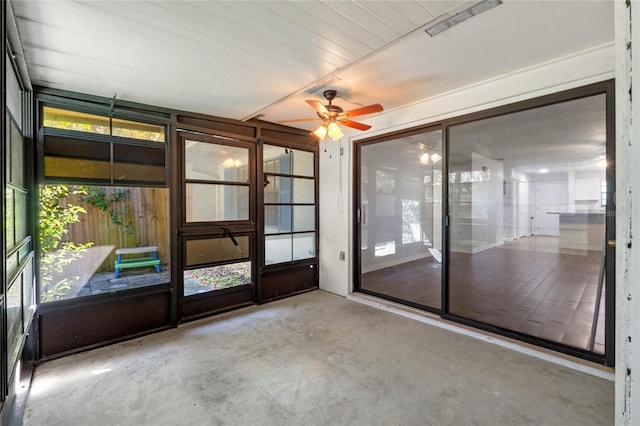 unfurnished sunroom with ceiling fan