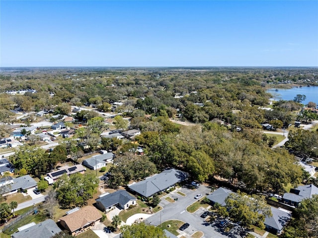 drone / aerial view with a forest view, a residential view, and a water view