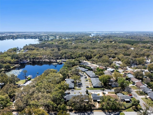 birds eye view of property featuring a wooded view, a water view, and a residential view