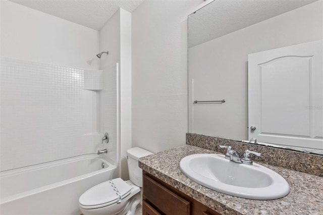 bathroom with shower / washtub combination, a textured ceiling, toilet, and vanity