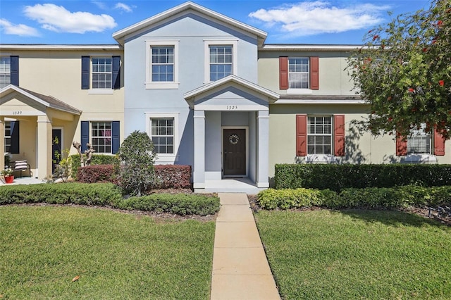 view of front of property with a front yard and stucco siding