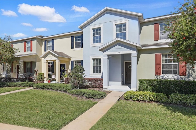 view of property featuring a front yard and stucco siding