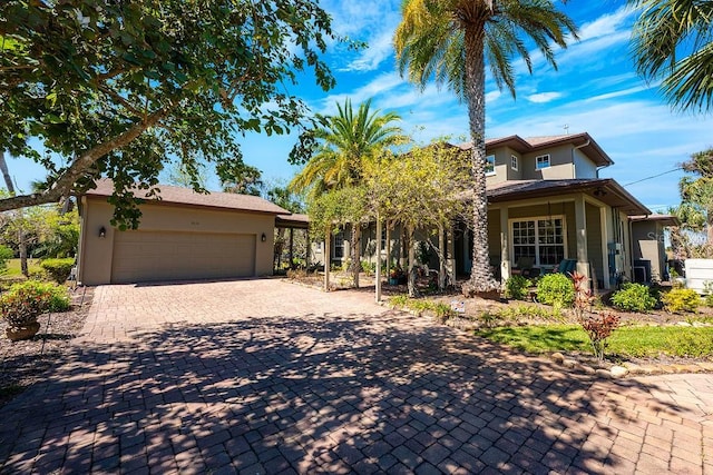 view of front of home with stucco siding, an attached garage, and decorative driveway