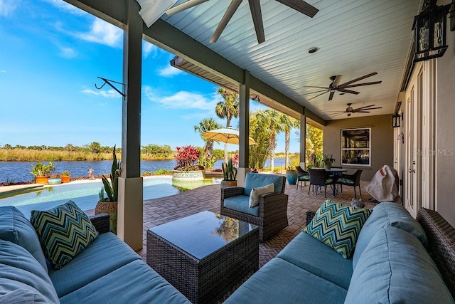 view of patio / terrace with outdoor dining space, an outdoor hangout area, a ceiling fan, and a water view