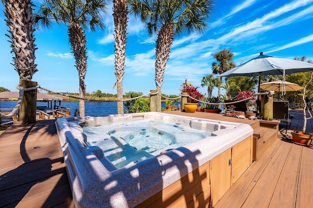 wooden terrace with a water view and a hot tub