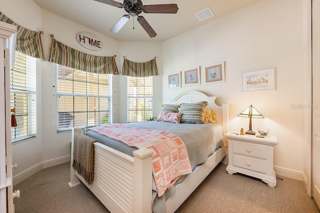 bedroom with baseboards, visible vents, and light carpet