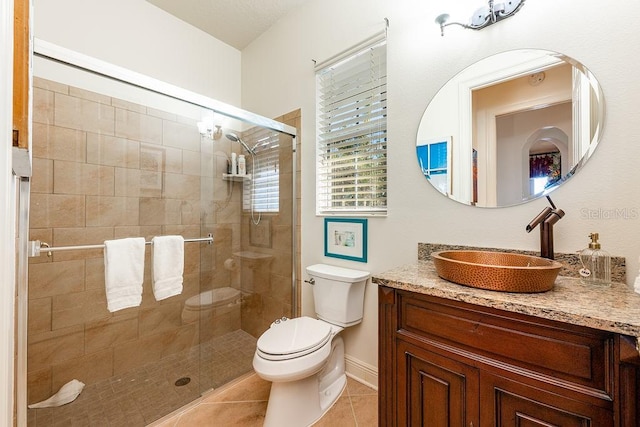 bathroom with tile patterned flooring, a shower stall, toilet, and vanity