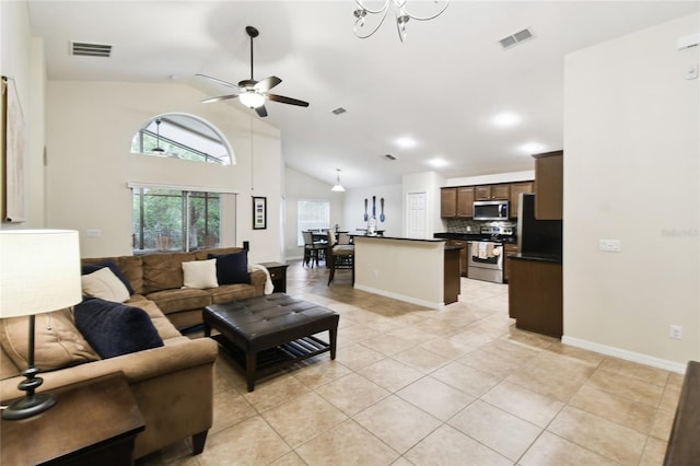 living room featuring a ceiling fan, visible vents, baseboards, high vaulted ceiling, and light tile patterned flooring