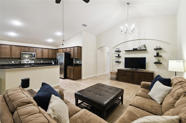 living area with light tile patterned floors, visible vents, baseboards, high vaulted ceiling, and arched walkways