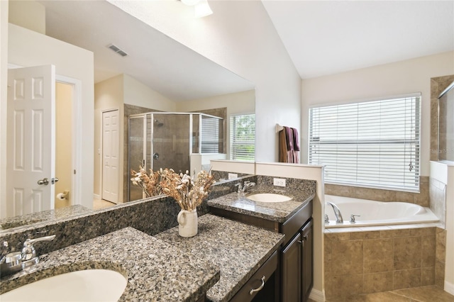 bathroom with visible vents, a shower stall, a bath, vanity, and vaulted ceiling