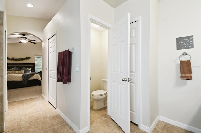 bathroom with tile patterned flooring, toilet, baseboards, and connected bathroom