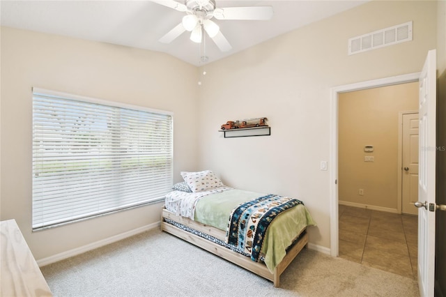 tiled bedroom featuring visible vents, a ceiling fan, carpet, baseboards, and vaulted ceiling